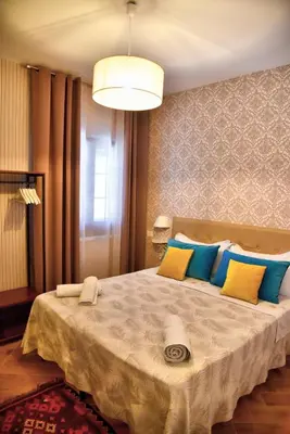 a bedroom with a large bed with blue and yellow pillows at Simo Amour in Lercara Friddi