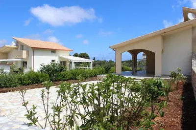 a house with a patio and a building at Borgo Aranci - Appartamento in Villa Rosa - 16B in Castellammare del Golfo