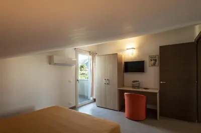 a bedroom with a bed and a desk with a television at Borgo Aranci - Appartamento in Villa Rosa - 16B in Castellammare del Golfo