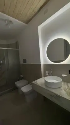 a bathroom with a sink and a toilet and a mirror at Cannatella's Mansion in Palermo