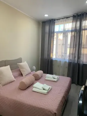 a bedroom with a pink bed with towels on it at Si Viaggiare Apartments in Partinico
