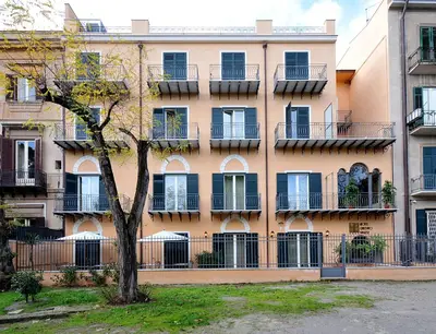 an apartment building with a tree in front of it at Hotel Giardino Inglese in Palermo