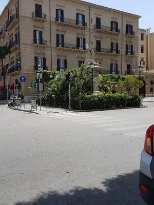 an empty street in front of a large building at B&B SAMMARTINO in Palermo