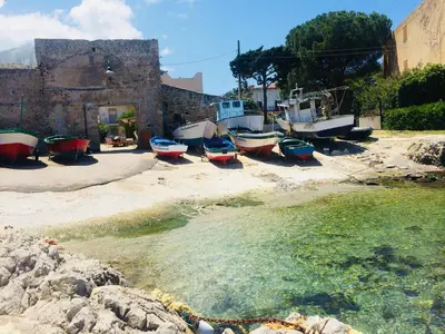 a group of boats sitting on the sand near the water at Villa MiraMar Exclusive Home Palermo Airport in Carini
