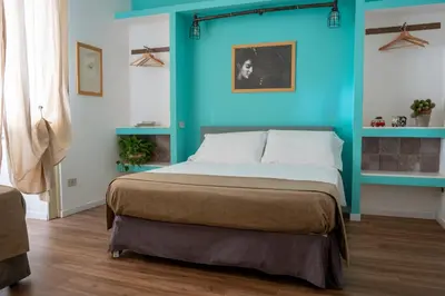 a bed in a room with a blue wall at Ai Vicerè in Palermo