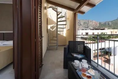a room with a balcony with a table with food on it at La Dimora del Pescatore in San Vito lo Capo