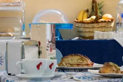 a table with a sandwich and a cup of coffee at La Dimora del Pescatore in San Vito lo Capo