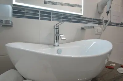 a white sink in a bathroom with a window at La Dimora del Pescatore in San Vito lo Capo