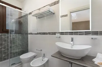 a bathroom with a sink and a toilet and a mirror at La Dimora del Pescatore in San Vito lo Capo