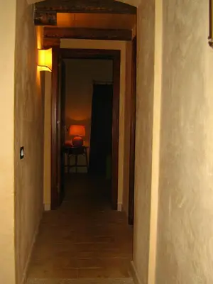 a hallway leading to a room with a table at the ancient sicilian house near zingaro reserve Scopello in Scopello
