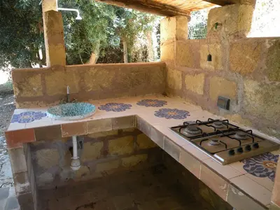 an outdoor kitchen with a stove and a sink at the ancient sicilian house near zingaro reserve Scopello in Scopello