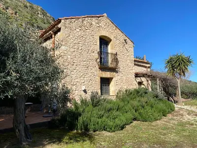 a stone house with a balcony on the side of it at the ancient sicilian house near zingaro reserve Scopello in Scopello