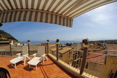 a balcony with white chairs and a view of the ocean at Le Sette Meraviglie in Castellammare del Golfo