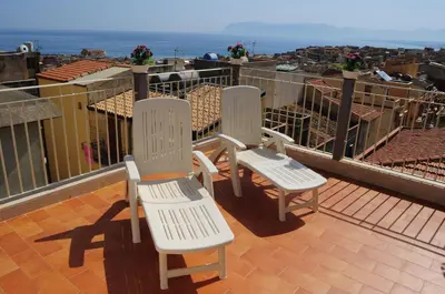 three white chairs sitting on top of a balcony at Le Sette Meraviglie in Castellammare del Golfo