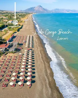 an aerial view of a beach with umbrellas and the ocean at House Cefalù 1915 in Lascari