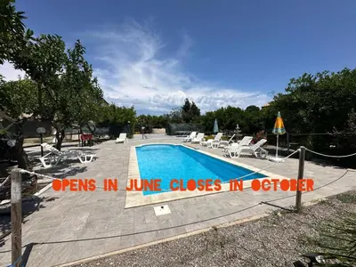 a swimming pool with lounge chairs and a sign that reads opens in june closes at House Cefalù 1915 in Lascari