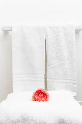 a red rose sitting on top of a white bed at Fuga Romantica vicino al Mare - Rental BeB in Balestrate