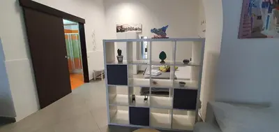 a white shelf with vases on it in a room at Loft in Balestrate vicino al Mare - Rental BeB in Balestrate