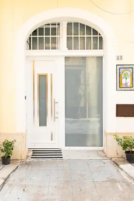 a white door of a building with a window at Loft in Balestrate vicino al Mare - Rental BeB in Balestrate