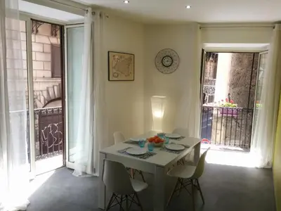 a white table and chairs in a room with windows at Cassaro Antico in Palermo