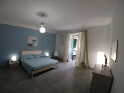 a blue bedroom with a bed and a window at Cassaro Antico in Palermo