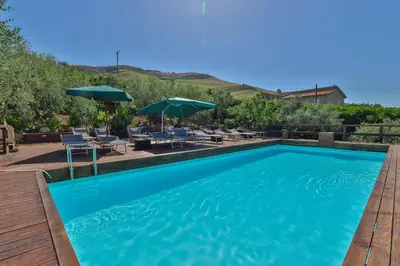 a large swimming pool with chairs and umbrellas at Al Lago Verde in Alia