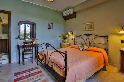 a bedroom with a bed and a table and a chair at Al Lago Verde in Alia