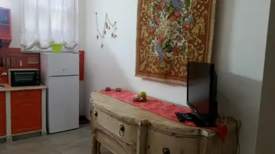 a kitchen with a tv on top of a wooden chest at Casa Marta in Palermo