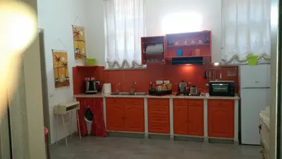 a kitchen with red cabinets and a white refrigerator at Casa Marta in Palermo