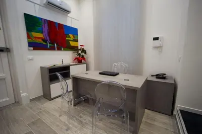 a room with a desk with two chairs and a painting at Palermo Gallery in Palermo