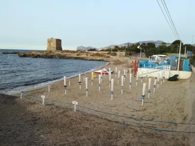 a beach with a bunch of poles in the sand at Le Terrazze in Carini