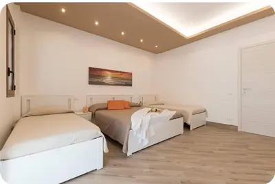 a bedroom with two beds and a painting on the wall at Rugiada Home Castellammare del Golfo in Castellammare del Golfo