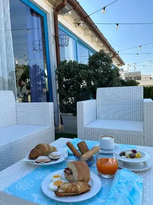 a table with plates of food and bread on it at Hotel Trinacria in San Vito lo Capo