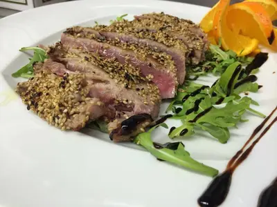 a plate of food with meat and salad on it at Hotel Trinacria in San Vito lo Capo