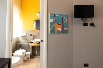 a bathroom with a toilet and a tv on the wall at B&B Montecarlo in Palermo