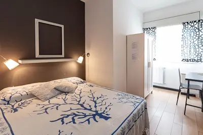 a bedroom with a bed and a table and a window at B&B Montecarlo in Palermo