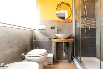 a bathroom with a toilet and a sink and a mirror at B&B Montecarlo in Palermo