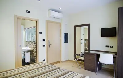 a bedroom with a bed and a desk and a television at BB 10 Serpotta - Palazzo Riolo & Restaurant in Palermo