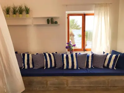 a blue couch with blue and white pillows on it at Marina Beach Resort by Le Dhome Sicily in Balestrate