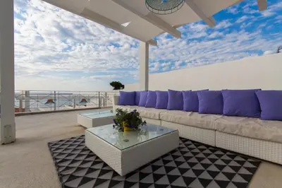 a living room with a couch and a view of the ocean at Marina Beach Resort by Le Dhome Sicily in Balestrate