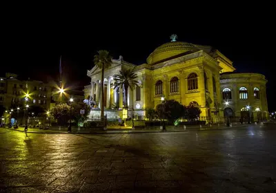 a large yellow building at night with lights at Palazzo Filangeri di Amorosa in Palermo
