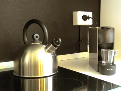 a tea kettle on a counter next to a coffee maker at Palazzo Filangeri di Amorosa in Palermo