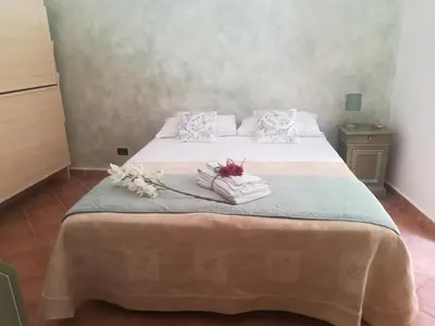 a bedroom with a bed with towels and flowers on it at La casetta alla Vucciria in Palermo