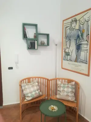 a room with two chairs and a table and a picture at La casetta alla Vucciria in Palermo