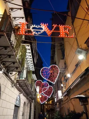 a group of heart lights hanging over a street at La casetta alla Vucciria in Palermo