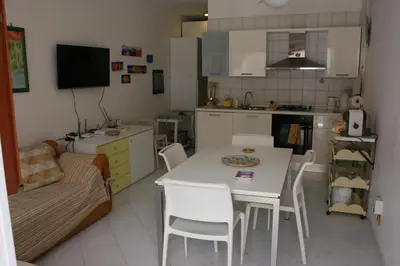 a kitchen with a white table and chairs and a couch at Casa Del Mulino a Vento in San Vito lo Capo
