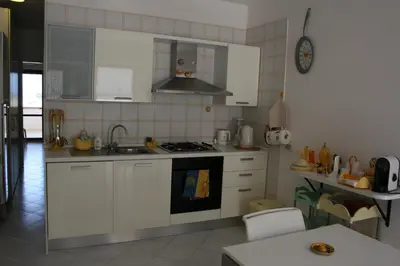 a kitchen with white cabinets and a stove top oven at Casa Del Mulino a Vento in San Vito lo Capo