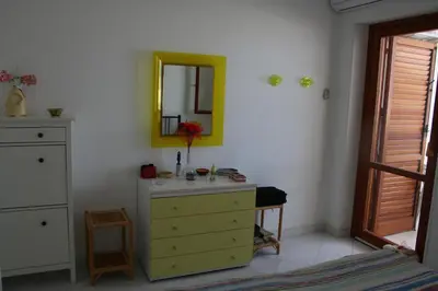 a bedroom with a yellow dresser and a mirror at Casa Del Mulino a Vento in San Vito lo Capo