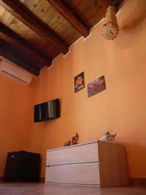 a room with a dresser and a tv on the wall at A Vanedda in Termini Imerese