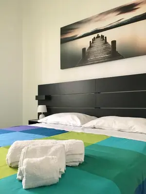 a bed with colorful sheets and towels on it at Casa Sciuti in Palermo